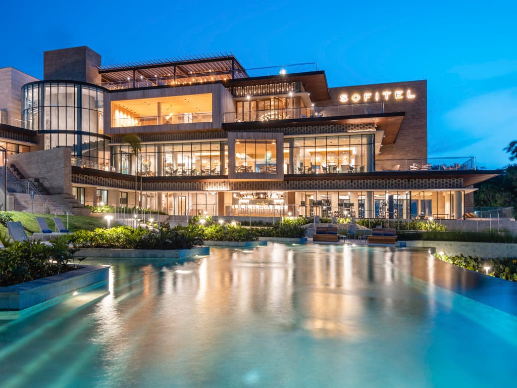 一位女士在Sofitel Barú Calablanca酒店陽台的私人小型游泳池中放鬆身心,俯瞰日落時的加勒比海。