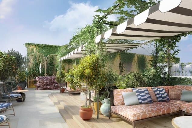 A stylish crowd mingling at the Otto Rooftop bar at W Rome with the historic Swiss Institute dome in the background.
