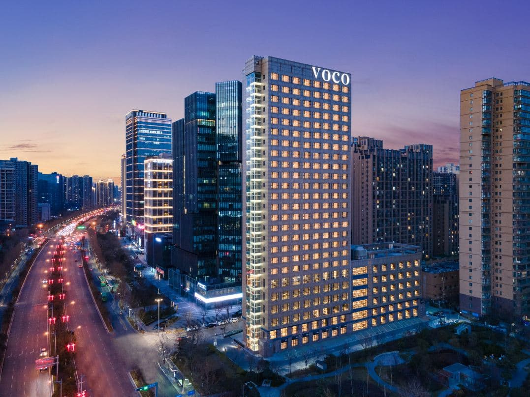 Modern guest room at Voco Xi An Etdz with plush bedding and city views, ideal for international travelers.