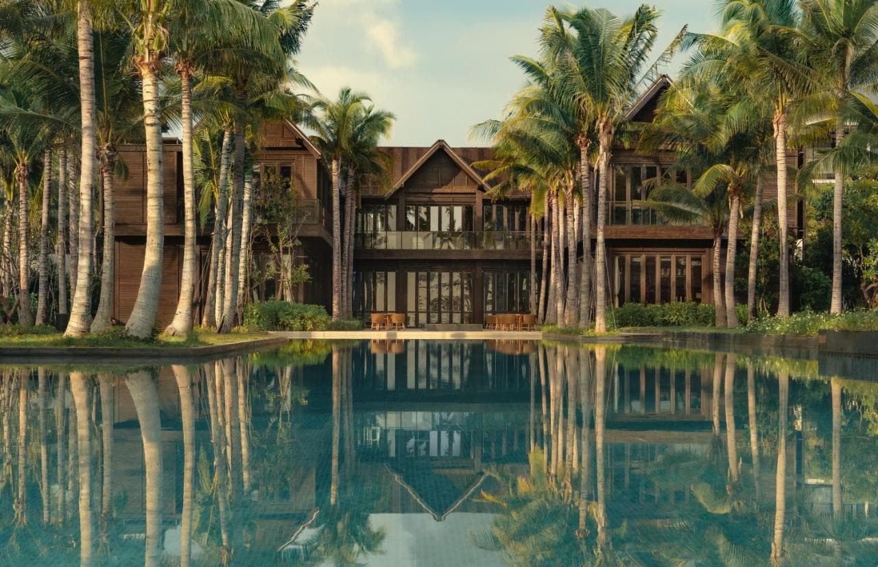 Kimpton Kitalay Samui's 50-meter infinity pool lined with black-and-white zebra umbrellas overlooking Choeng Mon Beach.
