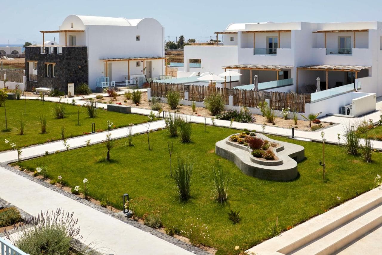 A white-washed suite with a private plunge pool overlooking the black sand beach at Sea Breeze Santorini.