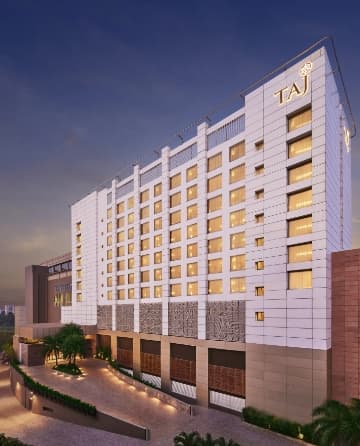 Knife-edge infinity pool at Taj City Centre New Town overlooking the airport runway at sunset.