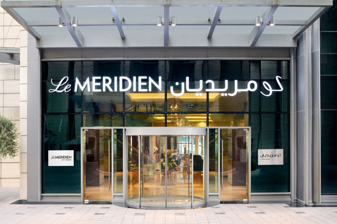 A sleek, sun-drenched indoor pool deck on the 43rd floor with floor-to-ceiling windows overlooking the Doha skyline.