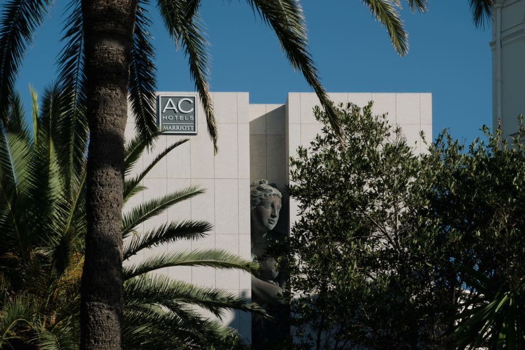 The brutalist facade of AC Hotel Nice featuring the giant bronze Sacha Sosno sculpture, contrasting with the blue Riviera sky.