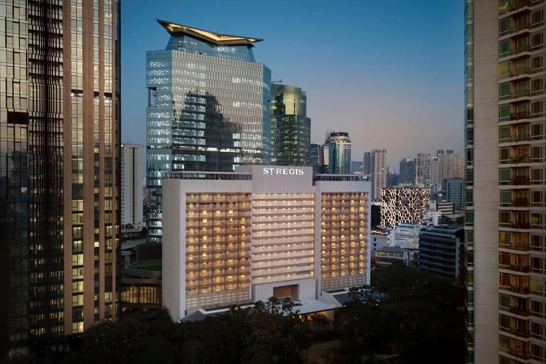 雅加达瑞吉酒店酒吧,配有爵士灵感壁画和萨克斯风造型吊灯,正值紫罗兰时光。