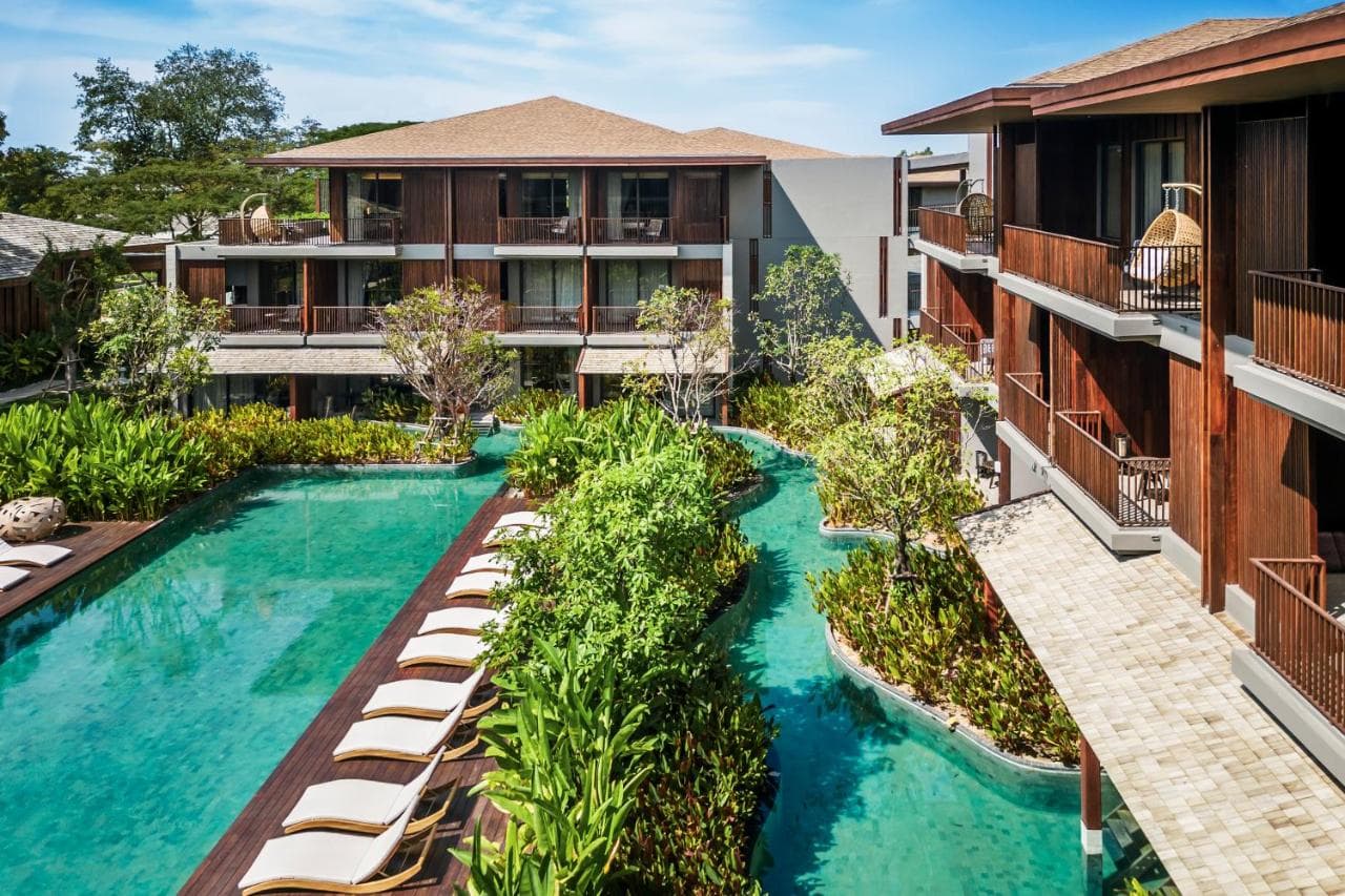 Sunset view of the Fish Club beachfront restaurant at Andaz Pattaya, featuring an infinity pool and palm trees against the Gulf of Thailand.
