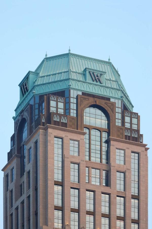 The Waldorf Astoria Doha West Bay's Art Deco facade towering over the Diplomatic Area, featuring the Tiffany & Co. Falcon Clock in the lobby.