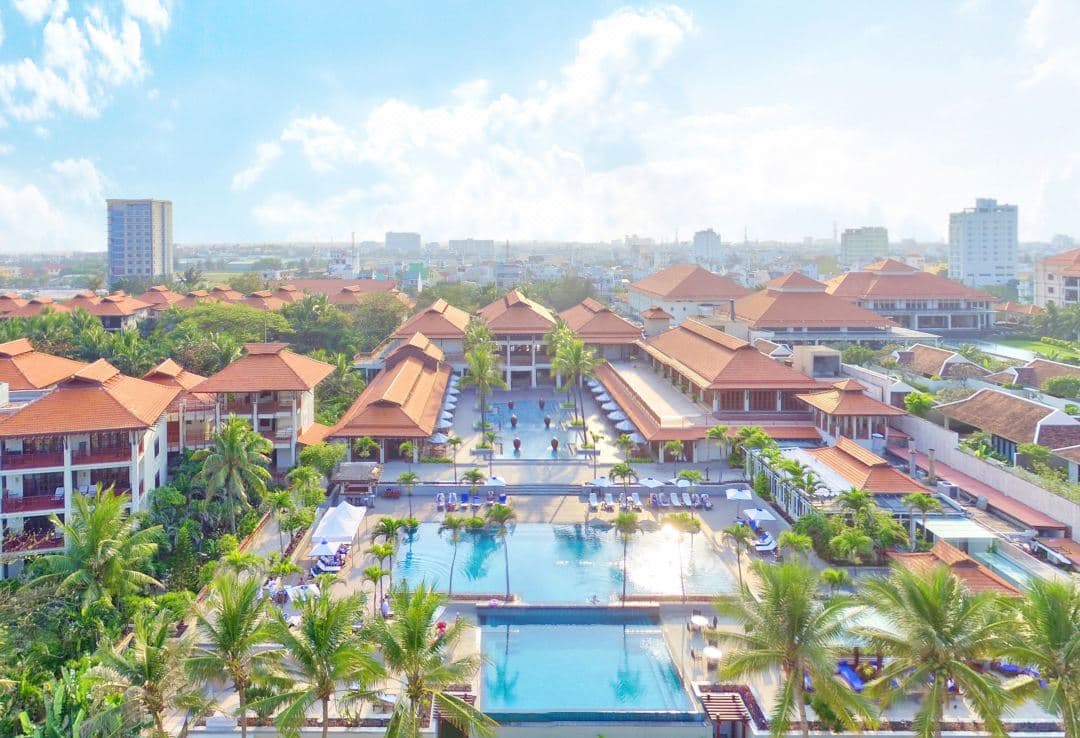 Furama Resort Danang lagoon pool surrounded by dense tropical jungle foliage and palm trees.