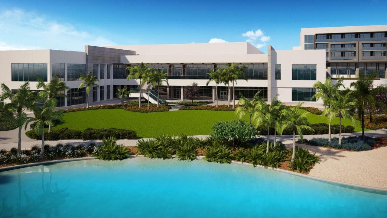 Lobby of Conrad Orlando featuring floor-to-ceiling windows overlooking the turquoise Evermore Bay lagoon.