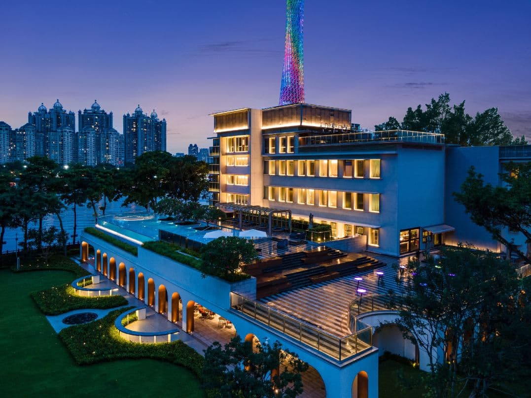 Exterior and scenic river views of Hotel Indigo Guangzhou Haixinsha with the Canton Tower.