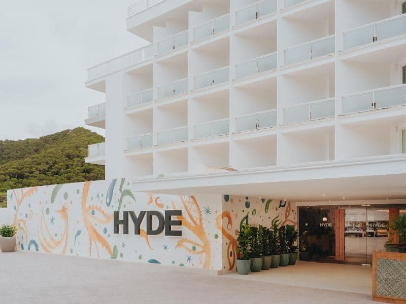 Hyde Ibiza Bungalow 泳池吧,配有超大藤编灯笼和俯瞰 Cala Llonga 湾的休息座位。