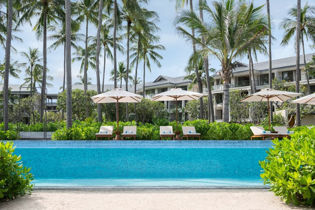 The open-air structure of Salt Society beach bar at Centara Reserve Samui, framed by palm trees and white sand.