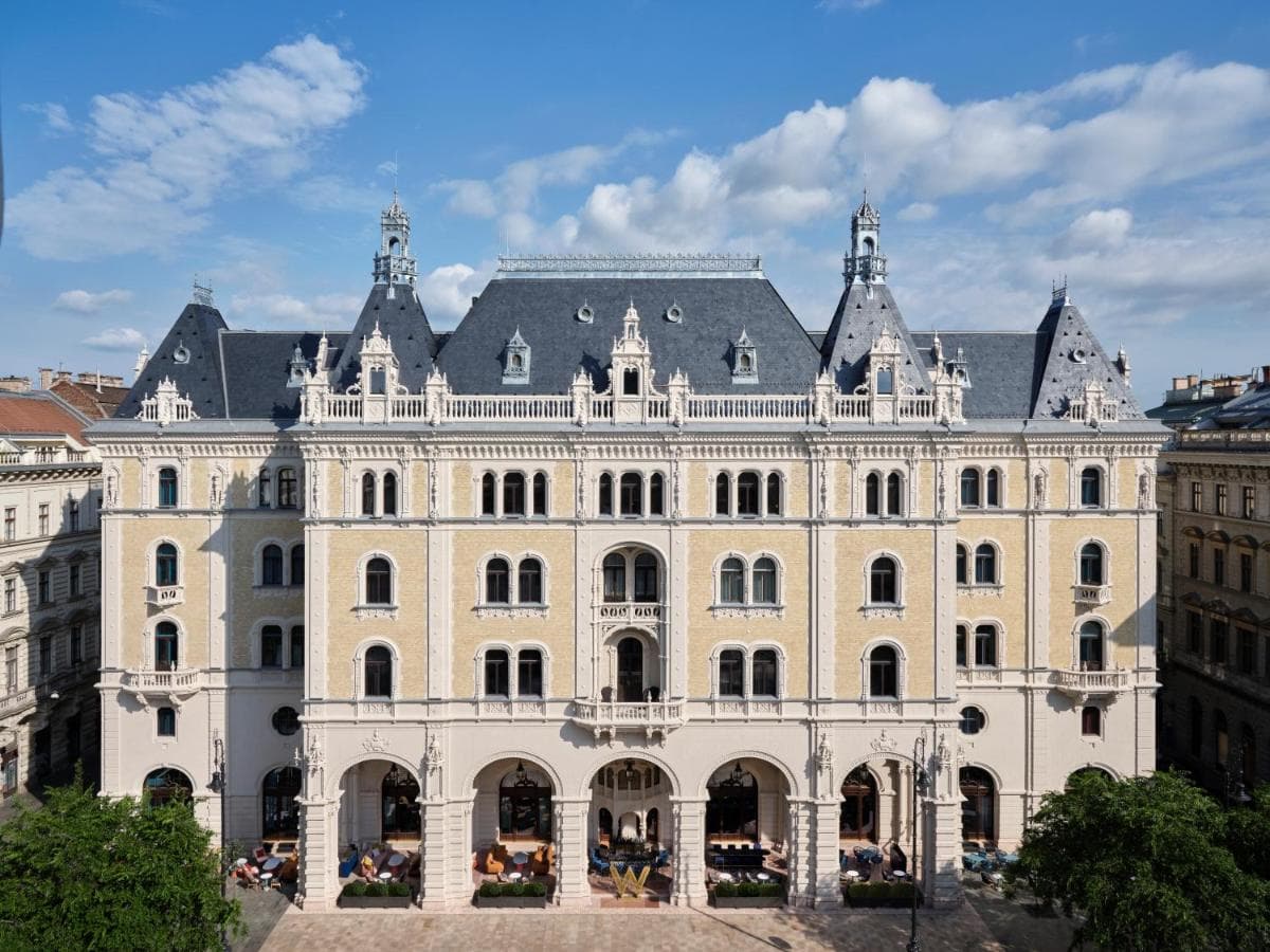The inner courtyard of W Budapest featuring a veil-like mesh ceiling and chessboard-inspired flooring under soft ambient lighting.