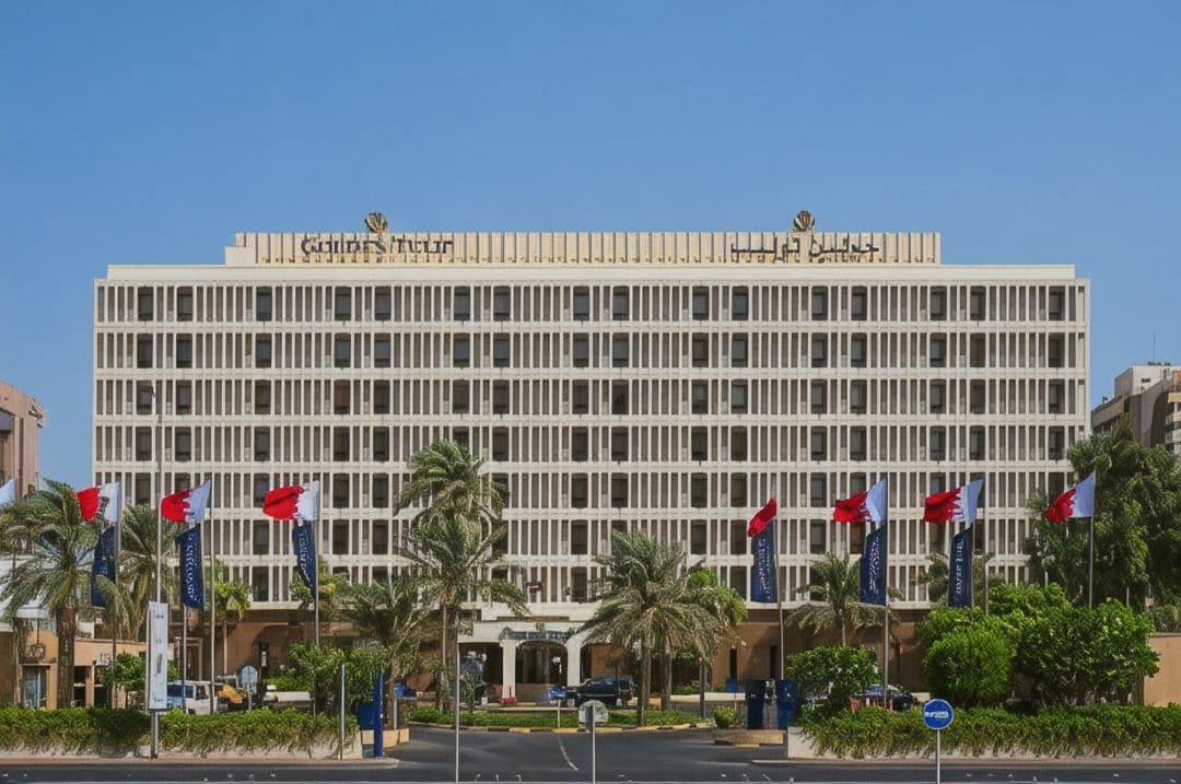 A view of the Golden Tulip Bahrain outdoor pool deck with the iconic dual towers of the Bahrain World Trade Center rising in the background.