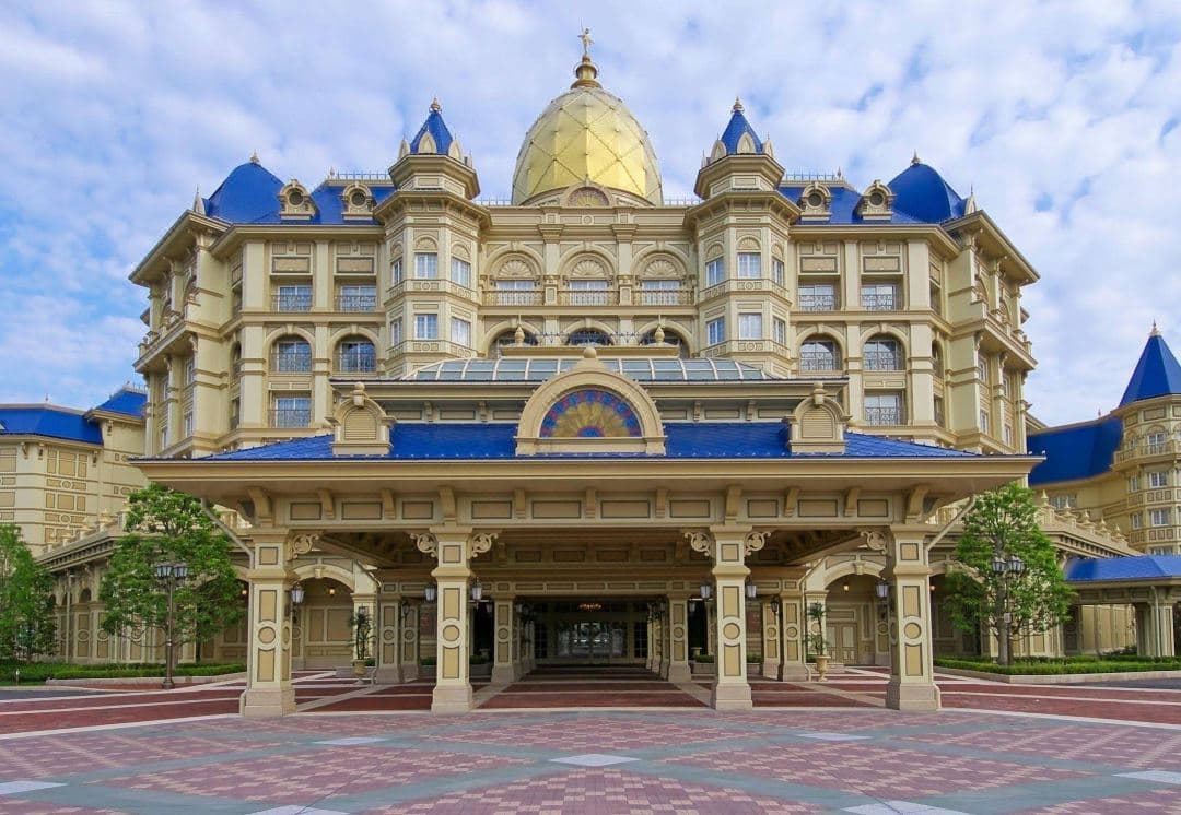 The soaring 30-meter ceiling of the Grand Atrium Lobby at Tokyo Disneyland Hotel, featuring Victorian architecture and a Mickey & Friends fountain.