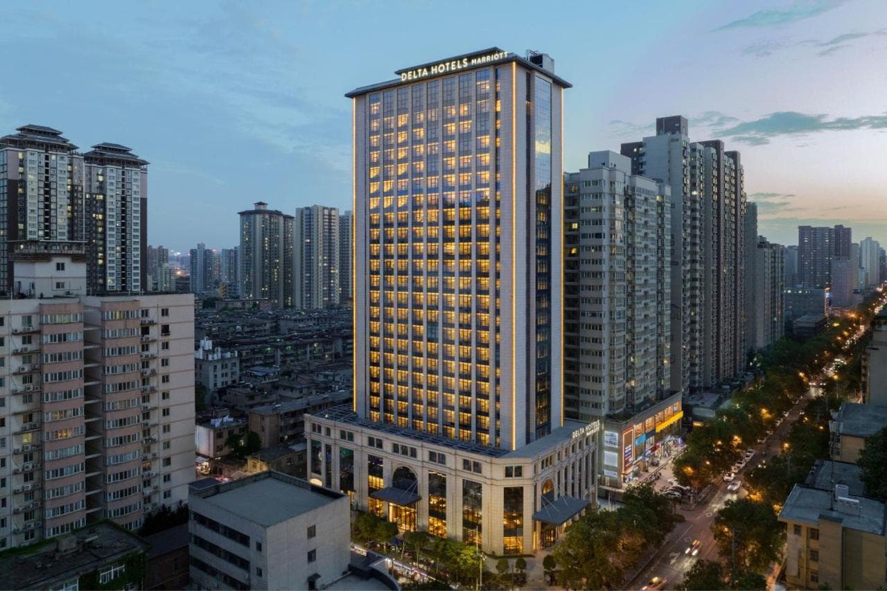 西安德爾塔酒店現代風格客房,配有抽象線條床頭板與全透明玻璃衛浴間。