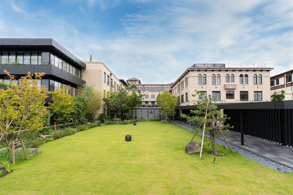 K36屋顶酒吧的客人正在享用鸡尾酒,背景是灯火通明的八坂塔和京都天际线。