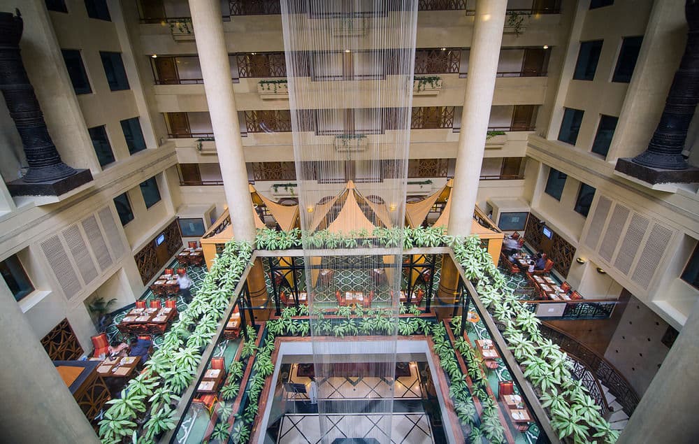 Looking down from the upper corridor at the 70-foot indoor waterfall inside The Orchid Hotel's atrium.