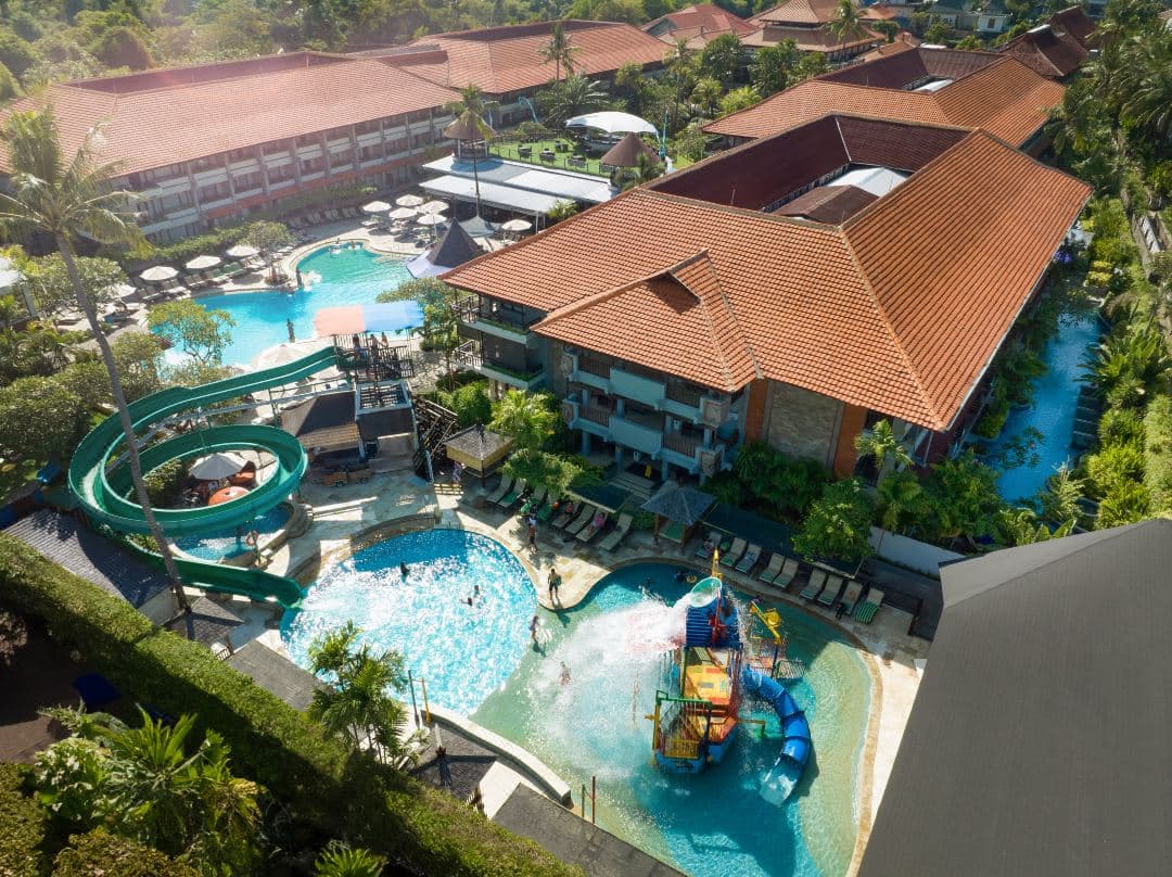 Aerial view of Bali Dynasty Resort featuring the winding Lagoon Pool and the Kids Water Fun Zone with its signature 56m yellow waterslide.