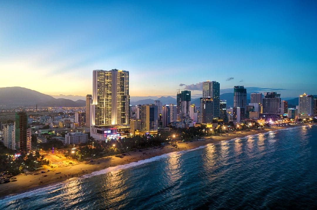 View of the infinity pool at Vinpearl Beachfront Nha Trang overlooking the ocean and city skyline.