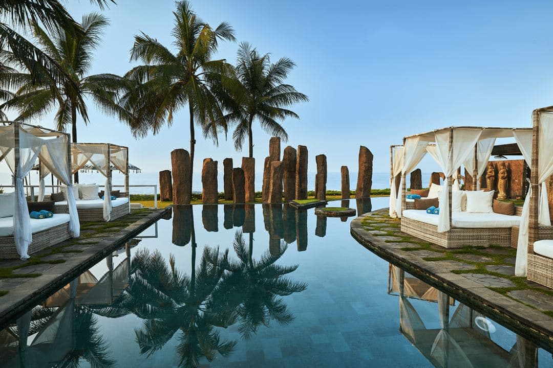 The Standing Stones restaurant megaliths framing a view of the black sand beach and ocean at The Royal Purnama.