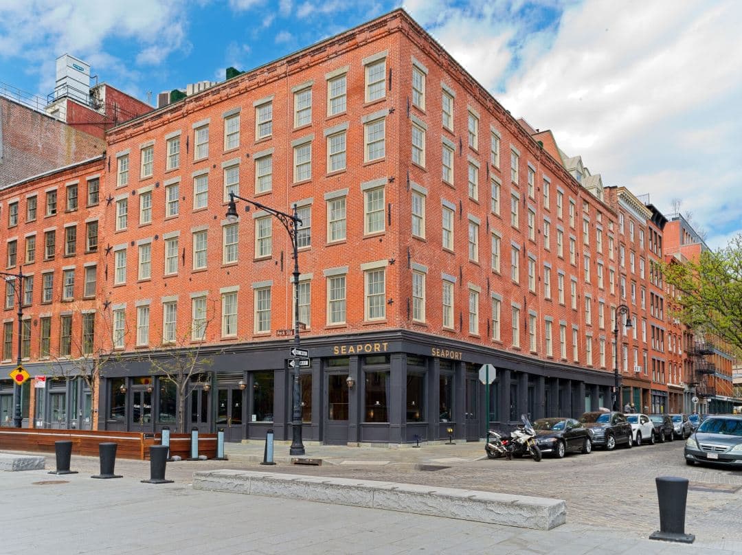 モダンな屋外家具が配置された33 Hotelの日当たりの良いプライベートテラス。イーストリバーと象徴的なブルックリン橋の構造を見渡せます。