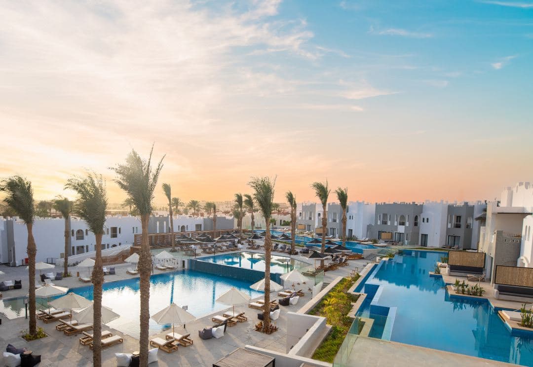 Boho-chic swim-up suites at SUNRISE Tucana Resort with wooden decks and Makadi Bay turquoise waters in the background.