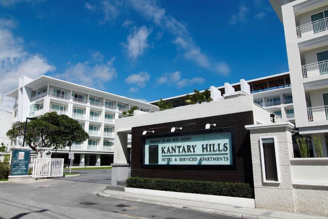 황혼의 하늘을 반사하는 Kantary Hills의 25m 야외 수영장과 대칭을 이루는 흰색 모더니즘 건물.
