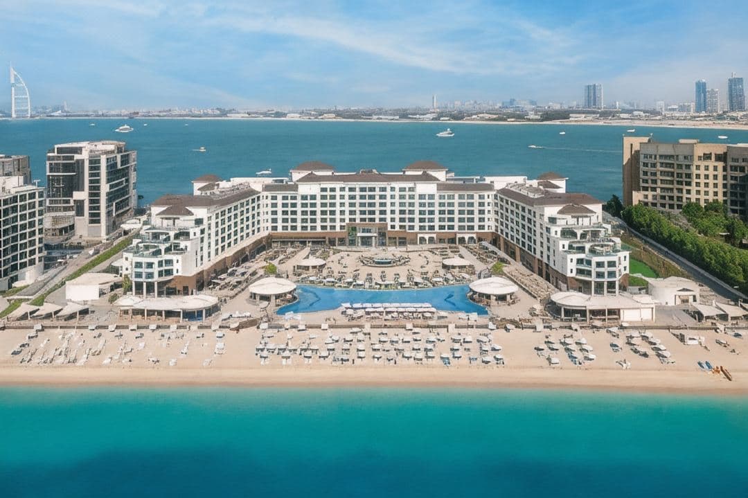 Expansive 70-meter infinity pool at Taj Exotica The Palm facing the Arabian Gulf at sunset.