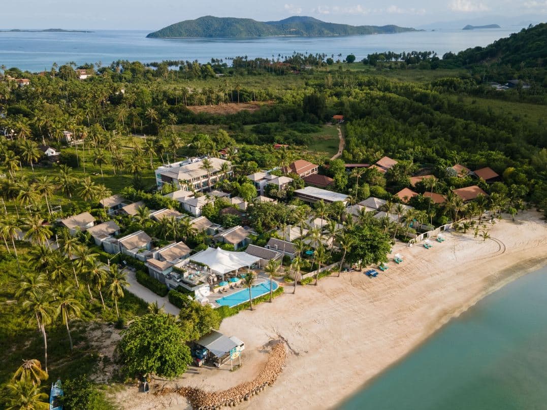 A vintage VW Kombi van converted into a pool bar at Avani+ Samui Resort, with guests enjoying cocktails at sunset.