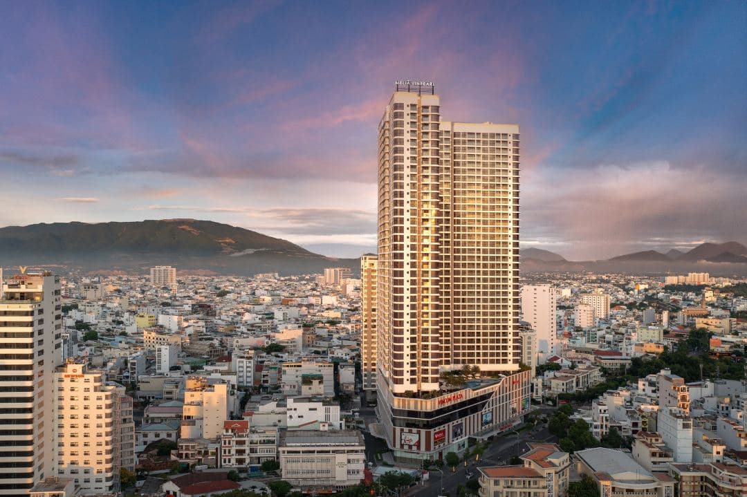 Melia Vinpearl Nha Trang Empire infinity pool edge overlooking the city skyline at twilight.