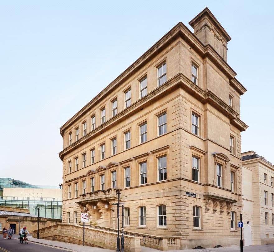The Gainsborough Bath Spa's Spa Village atrium featuring thermal pools, Romanesque columns, and a glass roof allowing natural light.