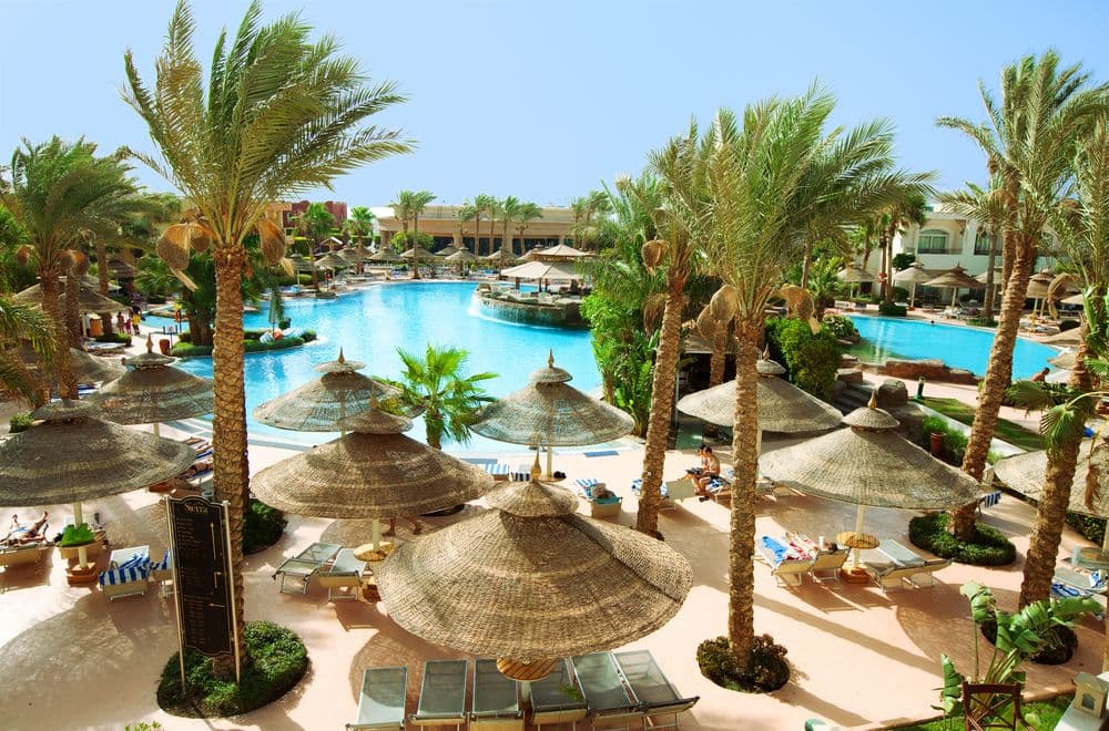 Night view of the Sierra Sharm El Sheikh pool illuminated against the backdrop of SOHO Square's lights.