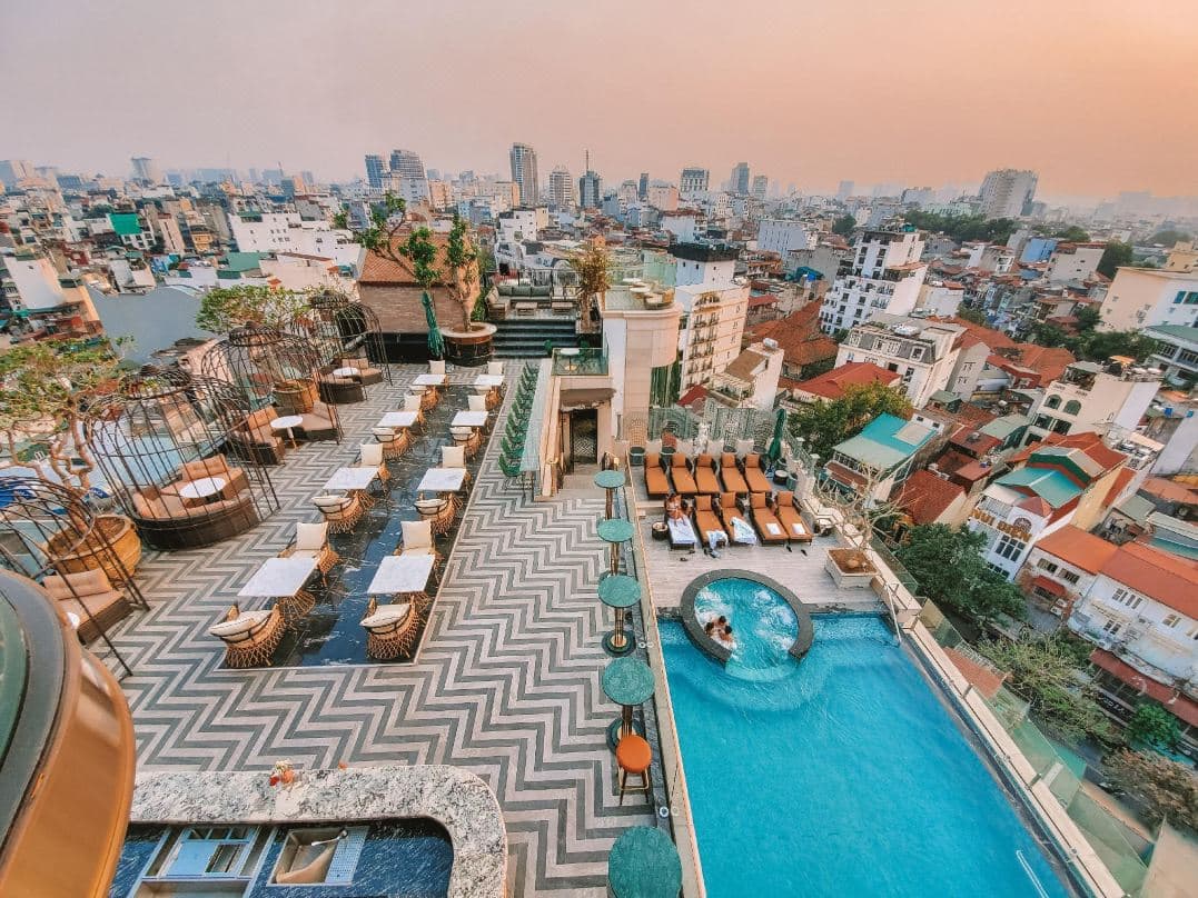A dramatic dusk view of the Ignite Sky Bar at Peridot Grand, featuring illuminated birdcage-style seating pods against the Hanoi skyline.