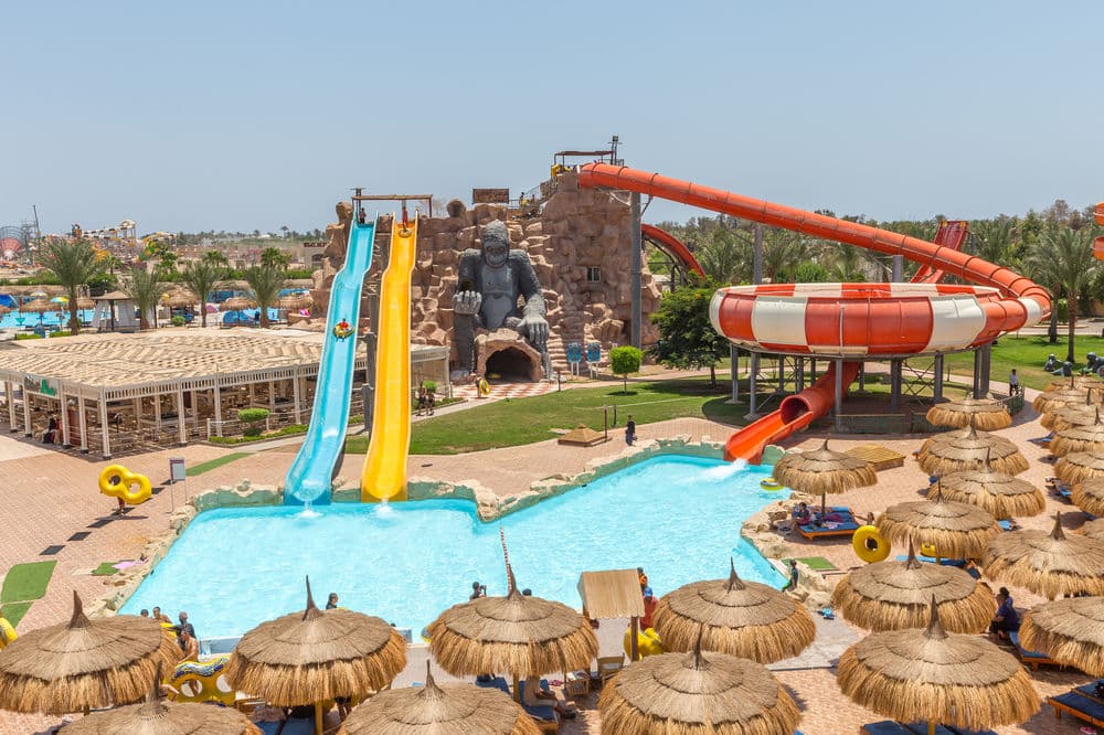 Aerial view of Pickalbatros Aqua Blu showing colorful water slide towers and the lazy river winding through the resort grounds.