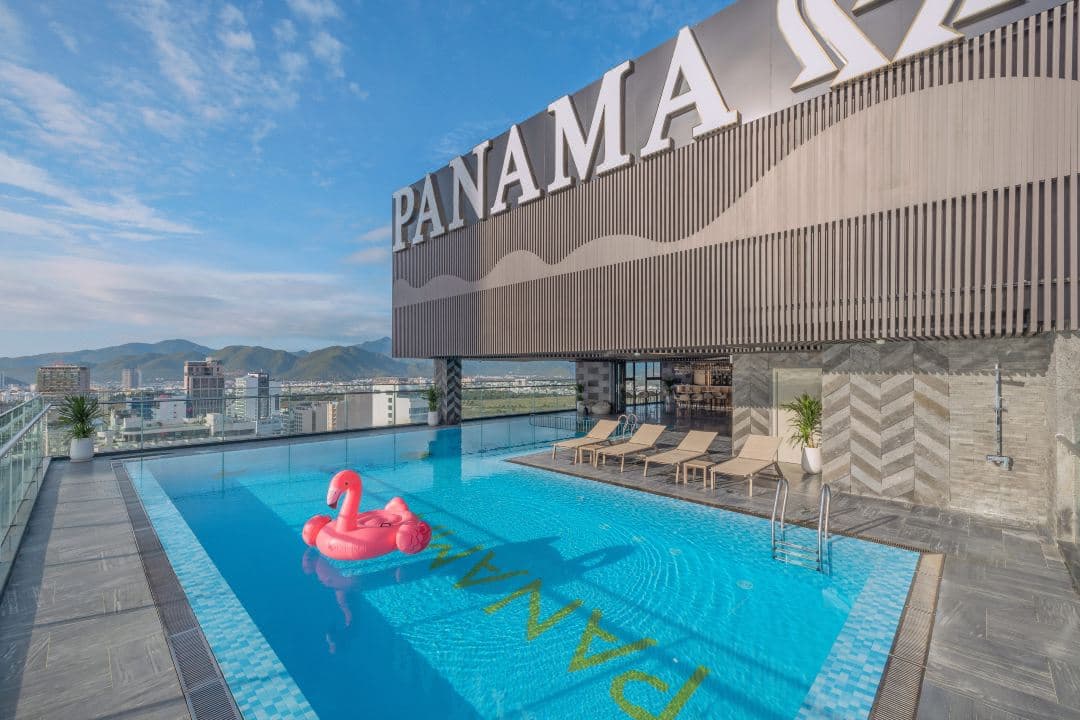 A dramatic dusk view from the 30th-floor infinity pool at PANAMA Nha Trang, overlooking the illuminated coastline and city lights.