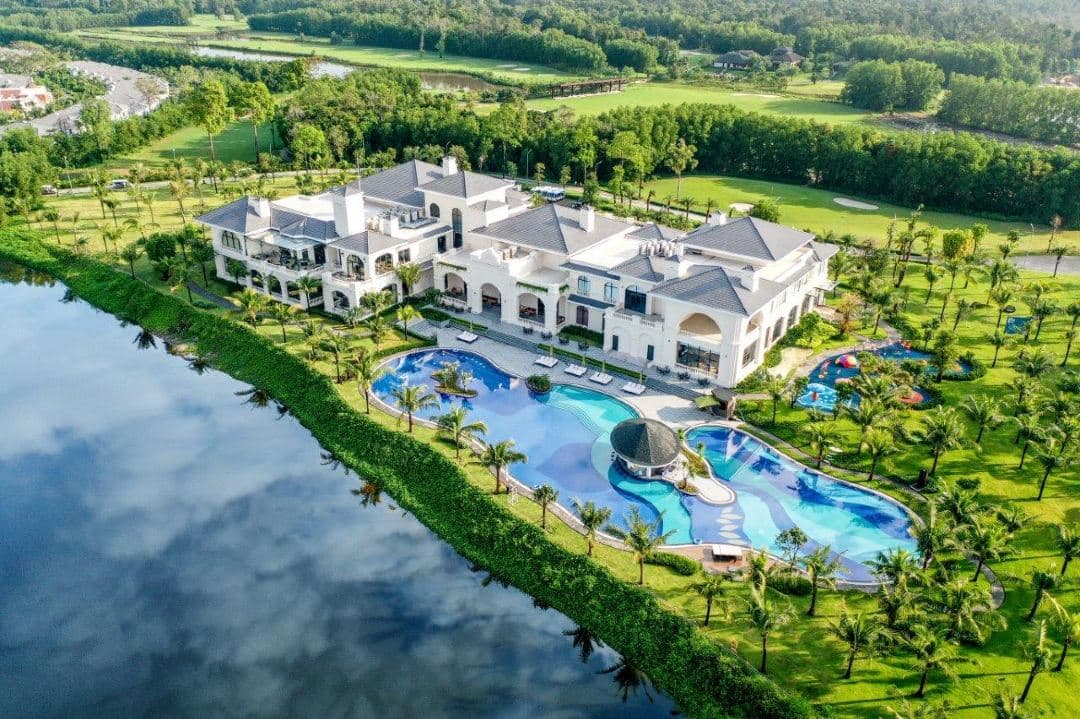 A private villa pool at Vinpearl Wonderworld Phu Quoc overlooking a serene lake at dusk.
