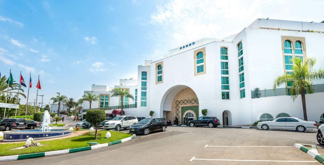 Hotel Borj Rabat 屋顶泳池的黄昏景色,背景是巍峨且灯火通明的哈桑塔。