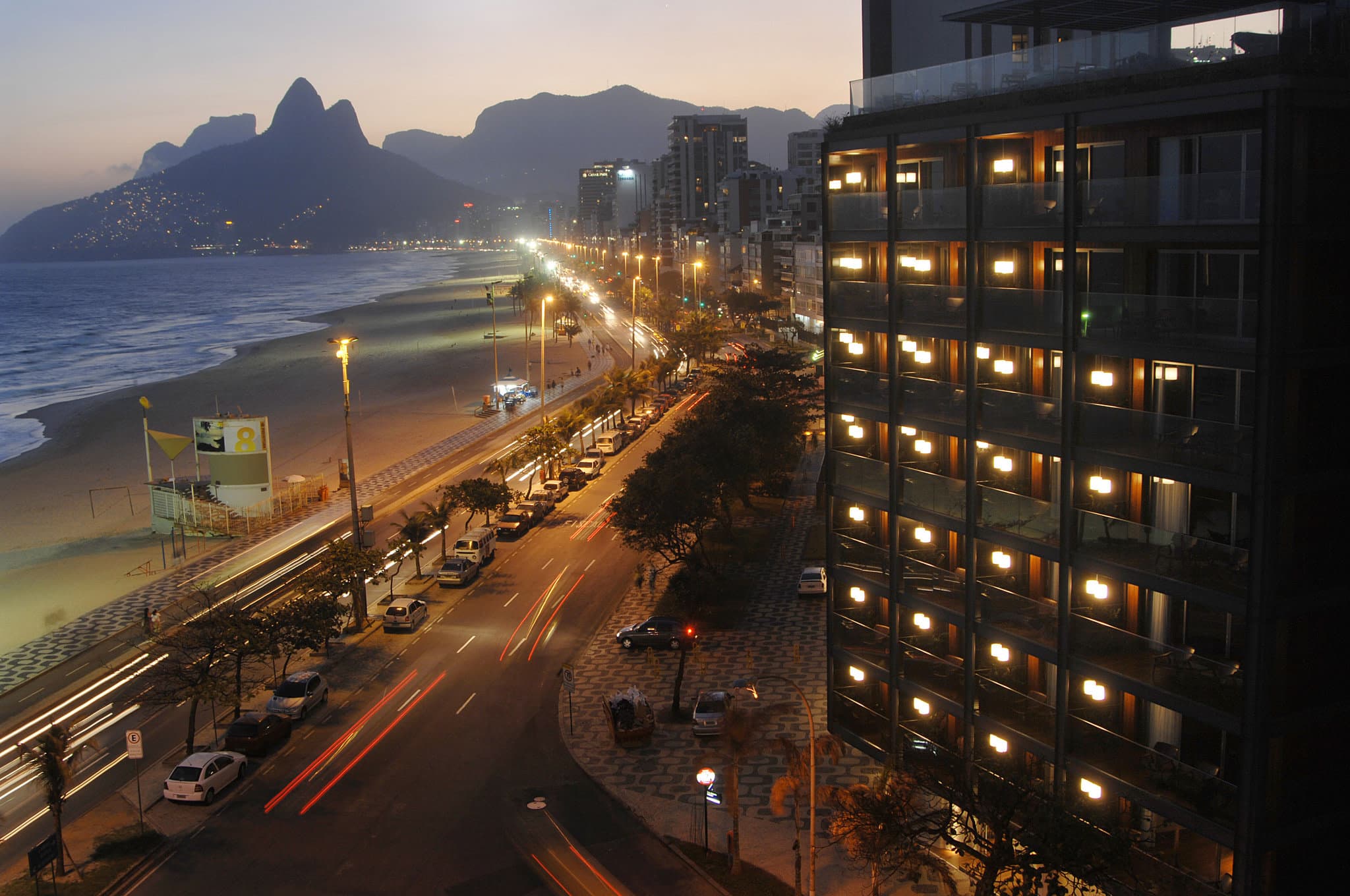 Rooftop infinity pool at Hotel Fasano Rio de Janeiro with guests lounging and the Two Brothers mountains in the background.