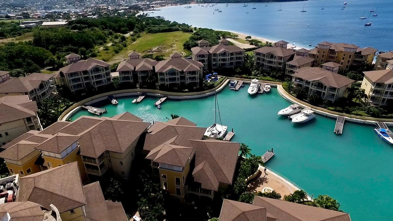 View of The Landings Resort private marina at twilight with illuminated yachts and resort suites in the background.