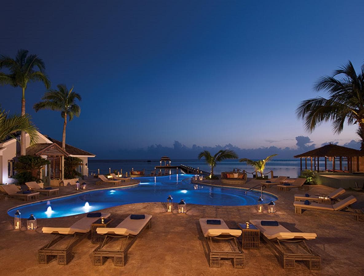 A serene infinity pool at Zoëtry Montego Bay at sunset, featuring the Pier Gazebo and calm Caribbean waters.