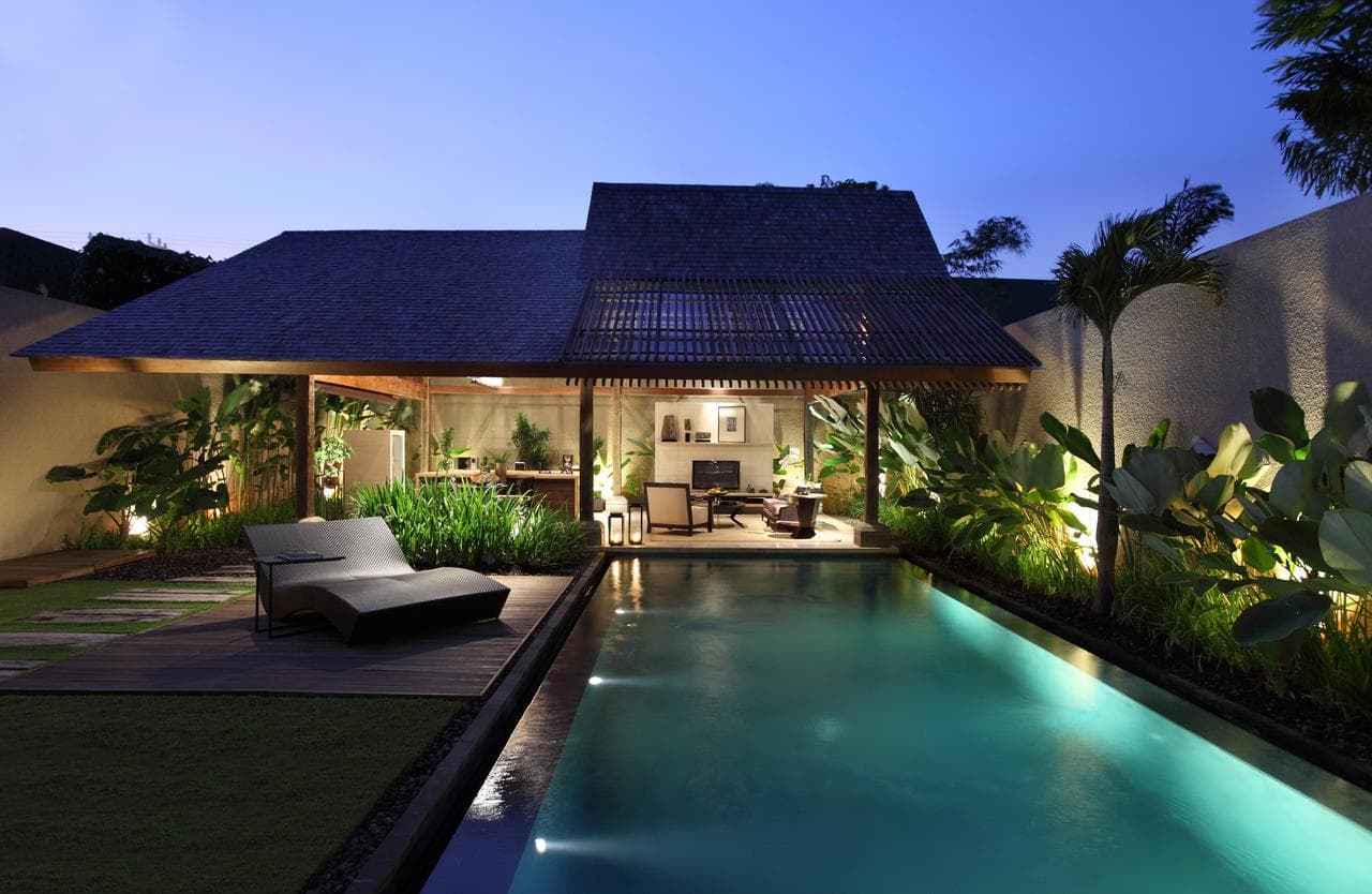 Ametis Villa Bali private pool surrounded by industrial-chic concrete walls and lush tropical greenery, featuring a floating breakfast tray.