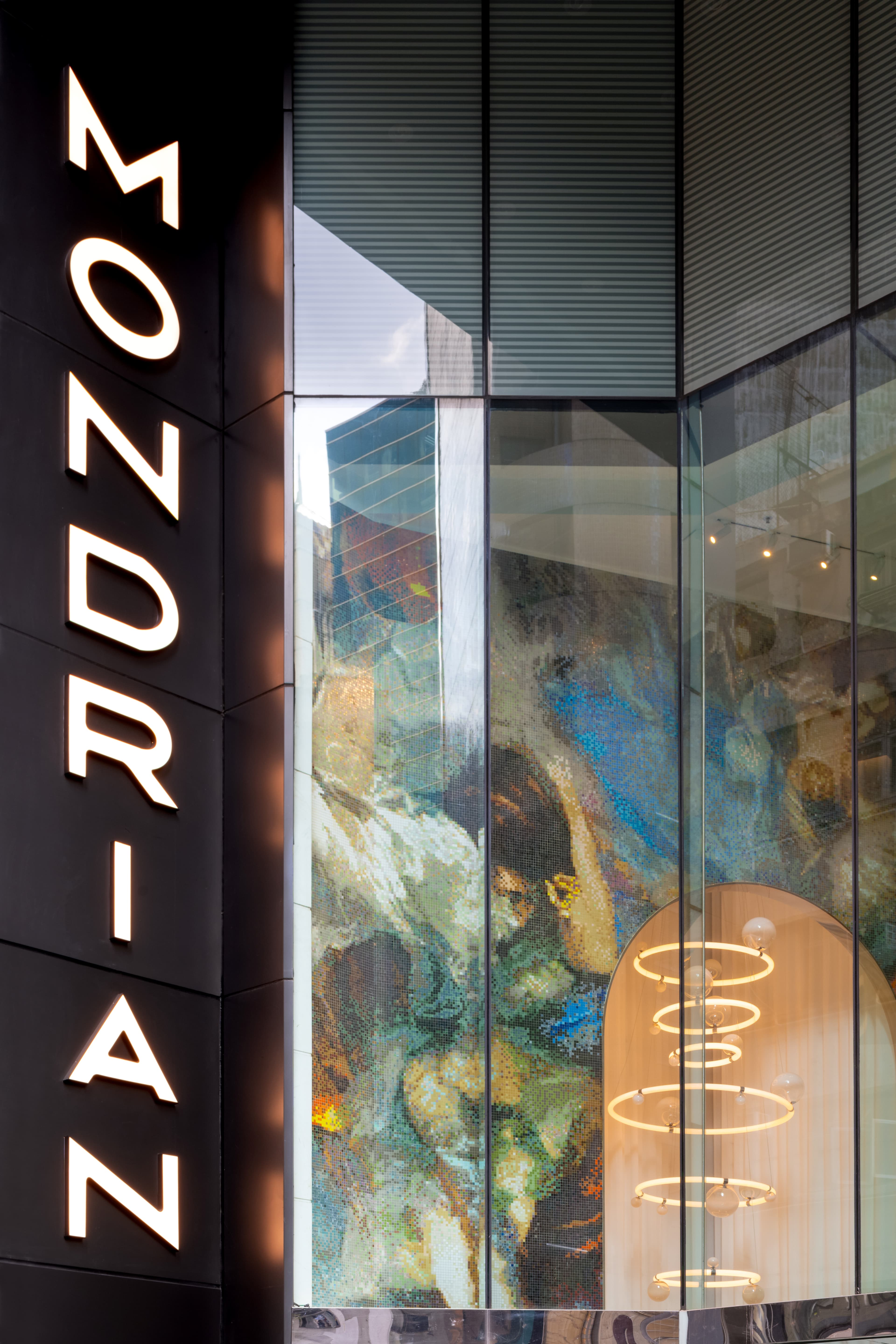 Low-angle view of Mondrian Hong Kong lobby featuring the massive underwater dancer mosaic by Christy Lee Rogers and geometric ceiling lights.