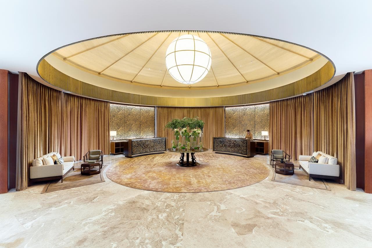The circular Lobby Dome at Capella Sanya featuring a dramatic water curtain falling into the central Dream Pool of Essays.