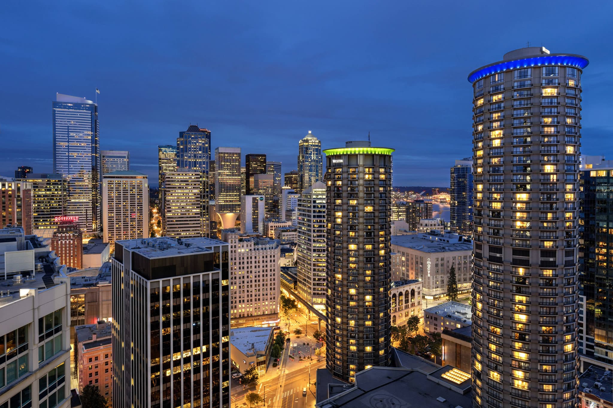 The cylindrical twin towers of The Westin Seattle rising above the downtown skyline with the Space Needle visible in the distance.