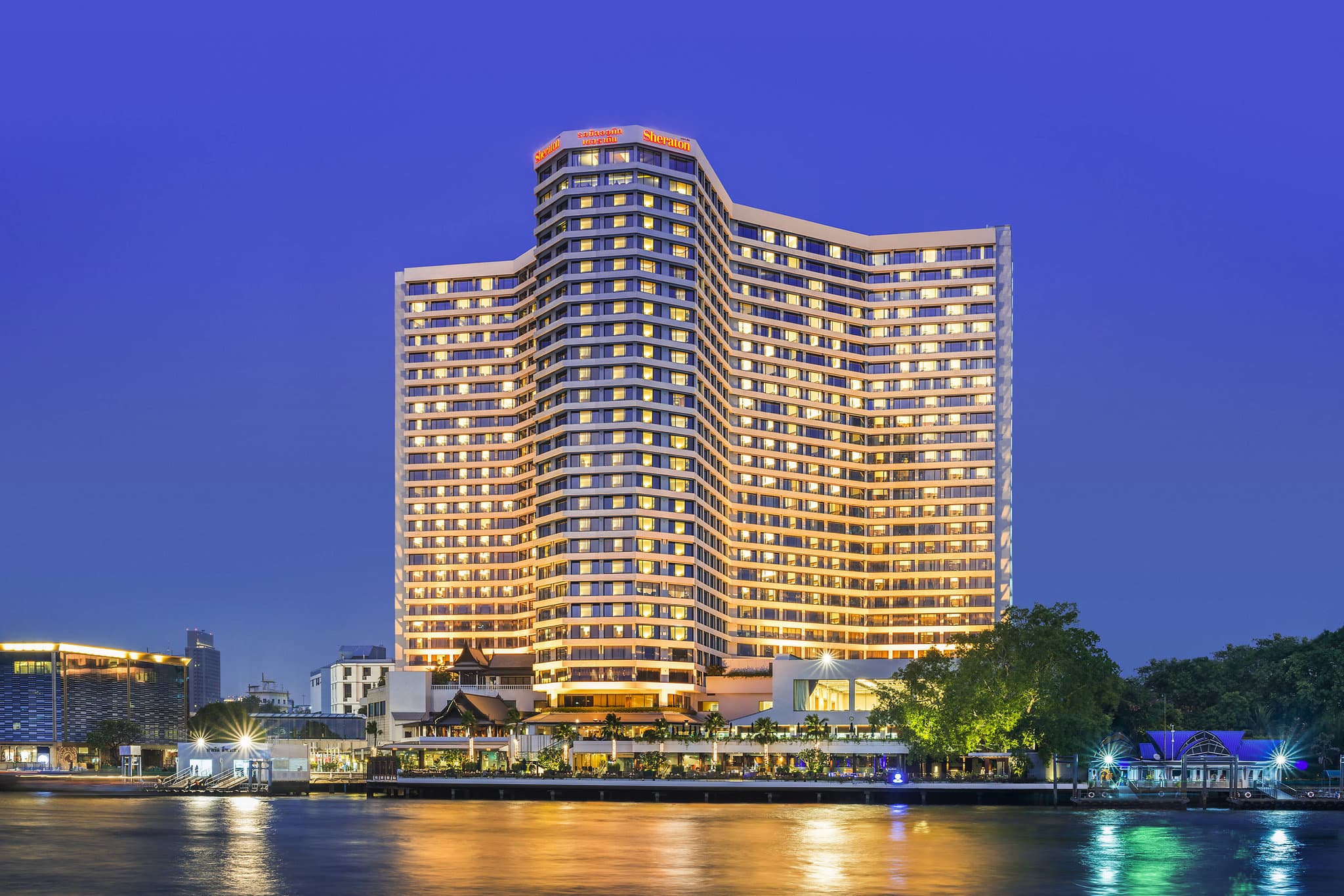 The Royal Orchid Sheraton's saltwater Terrace Pool overlooking the Chao Phraya River and ICONSIAM at sunset.