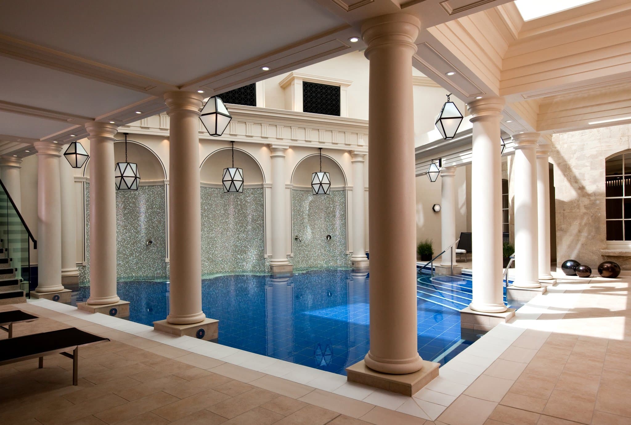 The Gainsborough Bath Spa's glass-roofed atrium pool with columns and thermal waters.