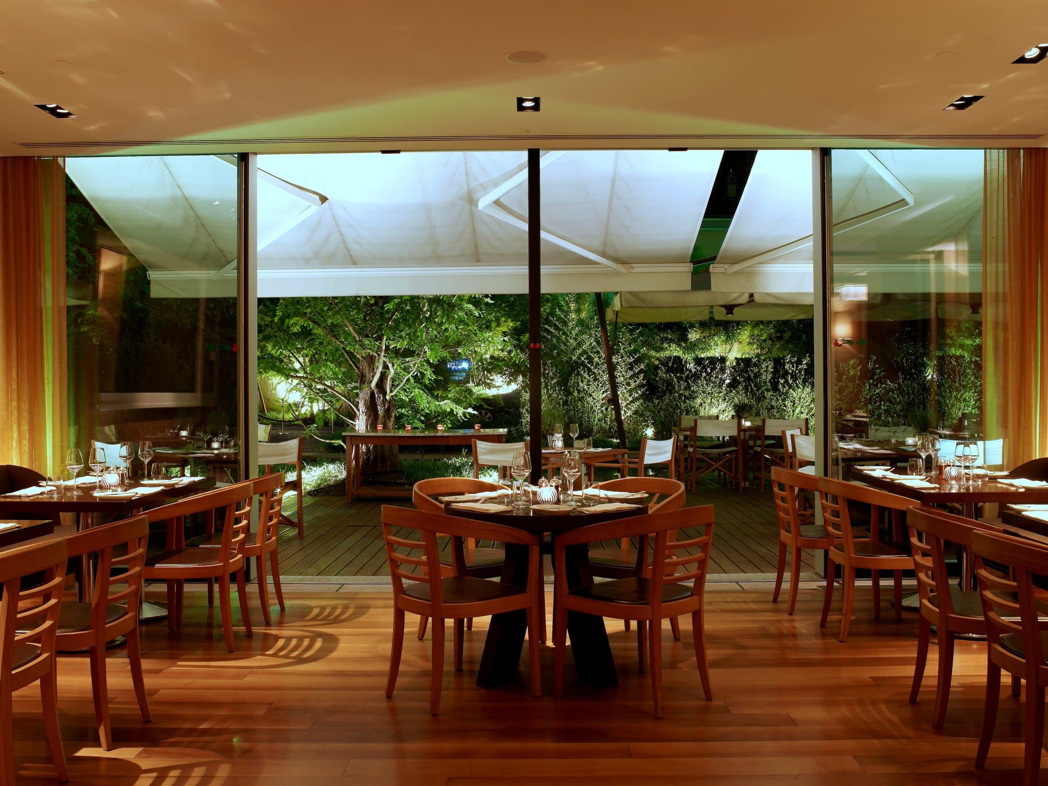 The 22-meter outdoor swimming pool at InterContinental Genève surrounded by lush gardens and lounge chairs.