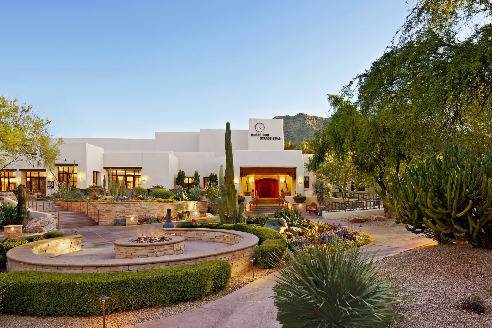 A sun-drenched private patio at the JW Marriott Camelback Inn with mid-century modern furniture, framing a view of Mummy Mountain.
