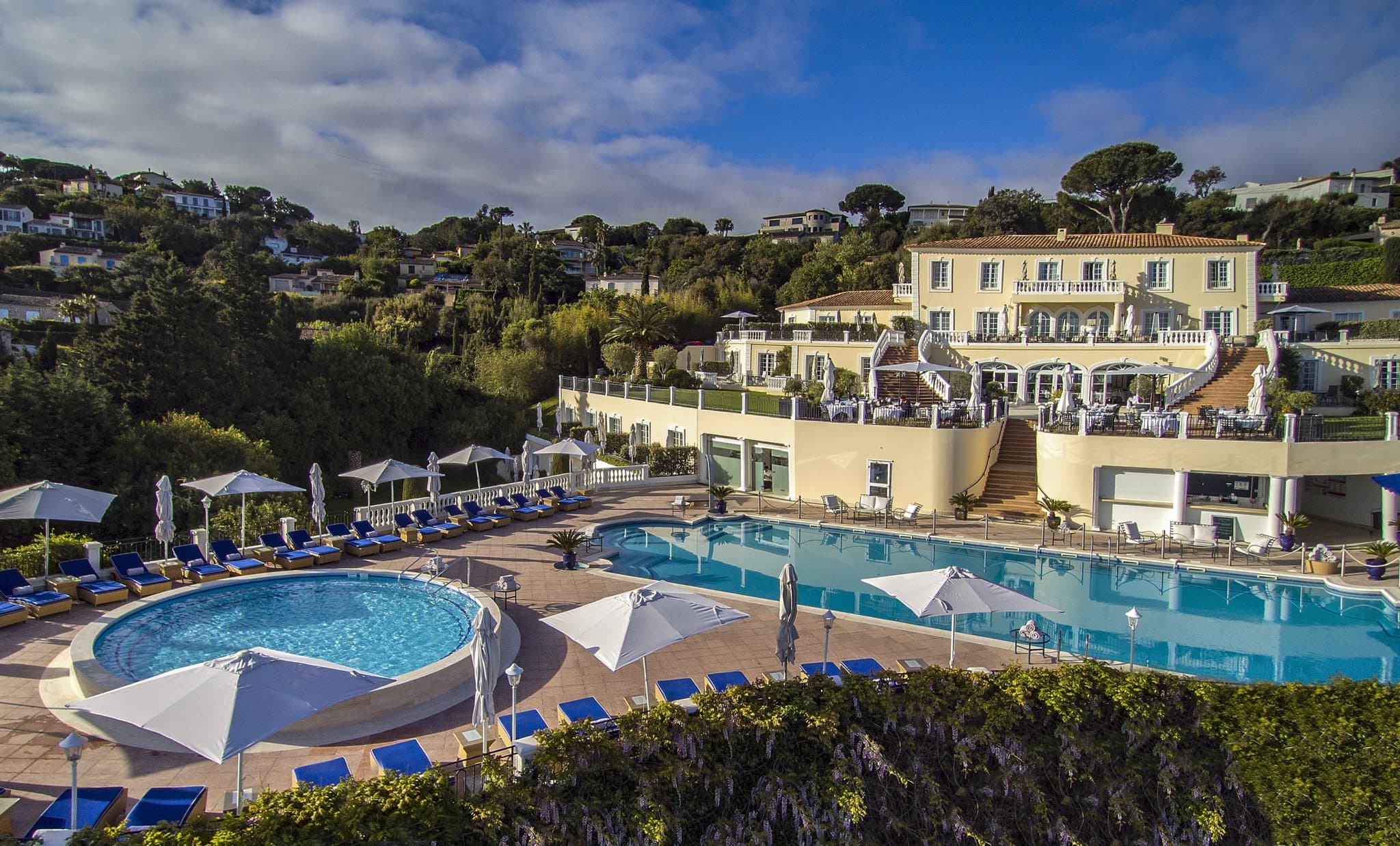Aerial view of Althoff Villa Belrose's 200sqm heated pool and double staircase overlooking the Bay of Saint-Tropez.